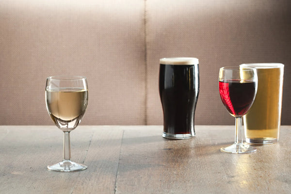 Een glas rode wijn en een glas bier: twee dranken vergeleken, met hun productie en hun cultuur